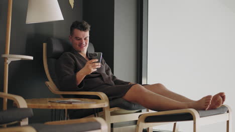adult-wealthy-man-is-resting-in-spa-salon-or-health-center-sitting-in-lounger-and-using-smartphone-viewing-positive-news